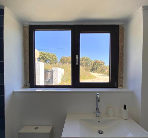 a bathroom with a window above a sink at Casas do Apeadeiro in Vimieiro