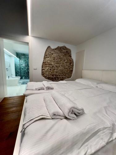 a bedroom with a large bed with towels on it at La Finestra Sul Ghetto in Padova
