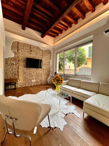 a living room with a couch and a brick wall at La Finestra Sul Ghetto in Padova