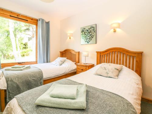 Duas camas num quarto com uma janela em Birchbank em Skye of Curr