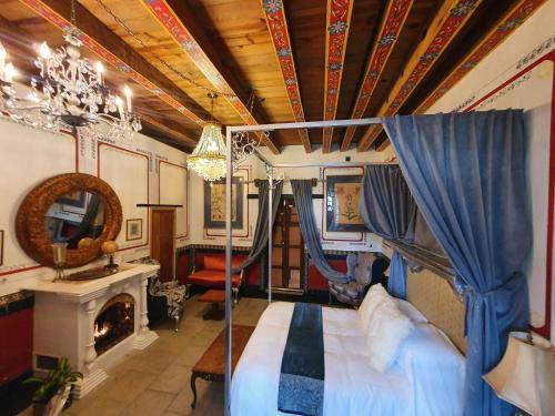 ein Schlafzimmer mit einem Himmelbett und einem Kamin in der Unterkunft Casa Dos Gallos in San Sebastián del Oeste