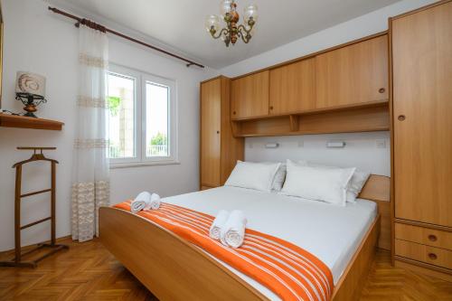 - une chambre avec un lit et 2 serviettes dans l'établissement Apartment MARIO - veliki stan za odmor - terasa- vrt - bazen - pogled more, izoliran, à Orašac