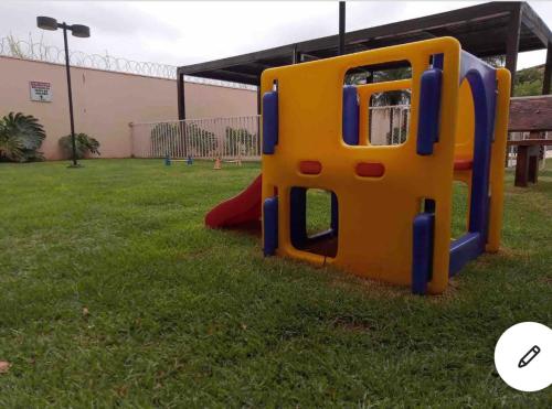 a playground with a slide in the grass at Loft completo e refinado in Ribeirão Preto