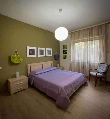 a bedroom with a purple bed and a chair at A CASA DI BOB in Matera