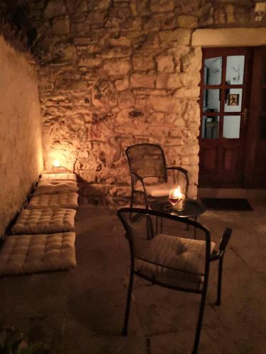 a table and a chair in front of a stone wall at George's rooms in Stari Grad
