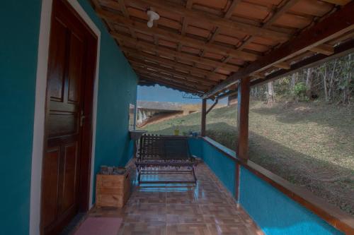 a porch with blue walls and a wooden roof at Chalés Cerejeira in Visconde De Maua