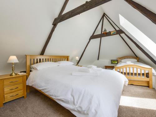 a bedroom with a white bed and two chairs at Bagtor Mill in Newton Abbot