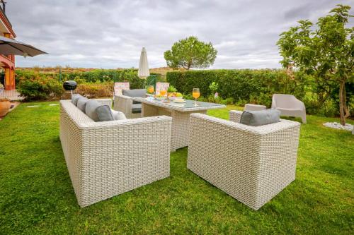 3 Korbstühle und ein Tisch im Hof in der Unterkunft Pura Villa- Buganvillas Ayamonte in Ayamonte