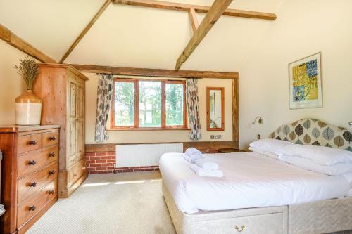 a bedroom with two beds and a dresser at The Cart Lodge in Halesworth