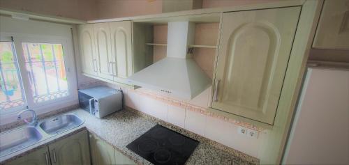 a small kitchen with a sink and a microwave at Apartamentos La Libertad Estepona in Estepona