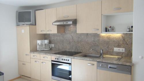 a kitchen with a sink and a stove at Haus Emberger in Gerlos