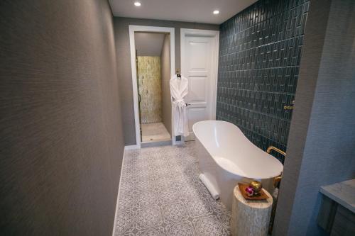 a bathroom with a white tub and a door at Bann at Oak Knoll Napa in Napa