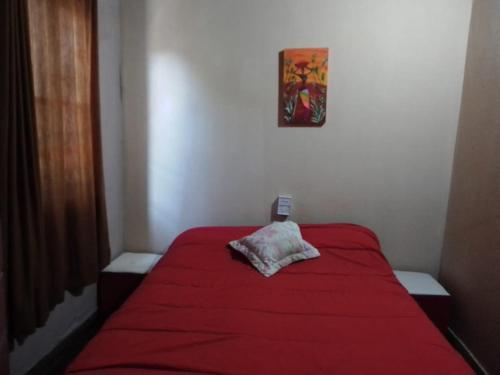 a bed with a red blanket in a room at Los Patos in Chumillo