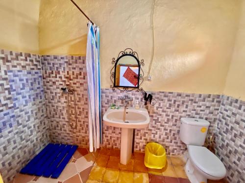 a bathroom with a sink and a toilet at Auberge Kasbah Des Dunes in Merzouga