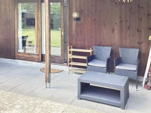 un patio con 2 sillas, una mesa y una puerta en 6 person holiday home in Idestrup, en Bøtø By