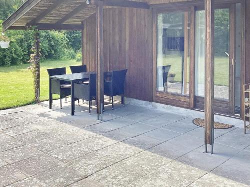 un patio con mesa y sillas. en 6 person holiday home in Idestrup, en Bøtø By