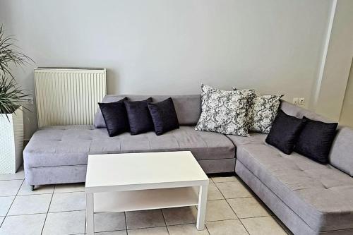 a living room with a gray couch and a white table at Ivanna apartment in Nea Moudania