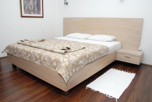 a bedroom with a large bed with a wooden headboard at Hotel Dunav Požarevac in Požarevac
