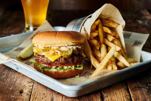 a hamburger and french fries in a tray with a drink at Holiday Inn Gatineau - Ottawa by IHG in Gatineau