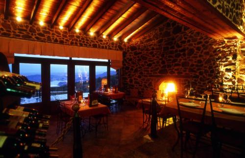 a restaurant with tables and chairs in a room with a window at Hotel Loggas in Kastoria