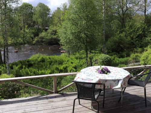 a table and chairs on a deck with a view of a river at 5 person holiday home in KNÄRED-By Traum in Knäred