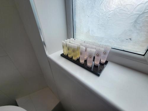 a group of four bottles sitting on a window sill at Garland Grangewood Central House, London in London