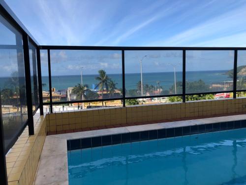 a swimming pool with a view of the ocean at Porto Viejo Ô de Casa Natal RN in Natal