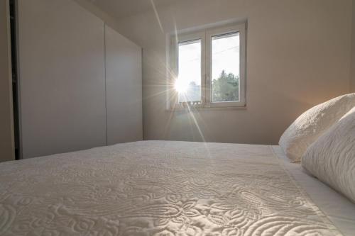 Apartment Ana في مارينا: غرفة نوم مع سرير مع ضوء الشمس من خلال النافذة