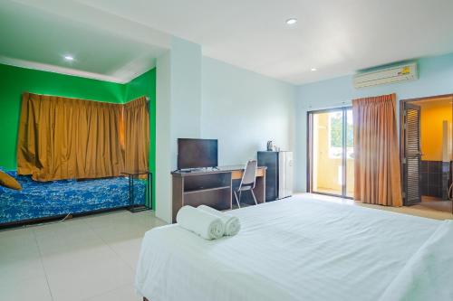 a bedroom with a large white bed and a television at AJ Residence in Phuket Town