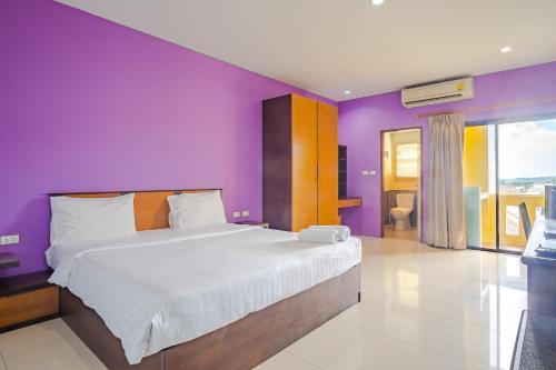 a bedroom with purple walls and a large bed at AJ Residence in Phuket Town