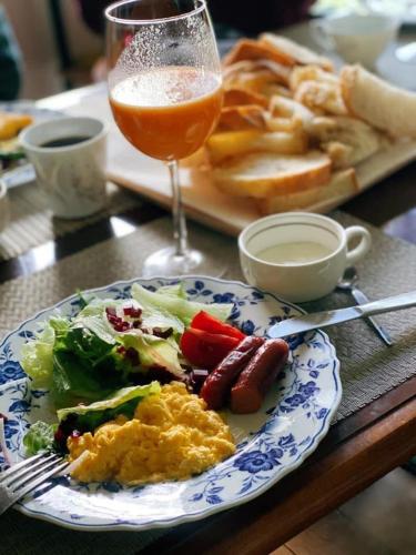 a table with a plate of food and a glass of juice at Kizuna Lodge & BBQ Centre in Hakuba
