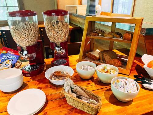 a wooden table topped with two vases filled with food at Kizuna Lodge & BBQ Centre in Hakuba