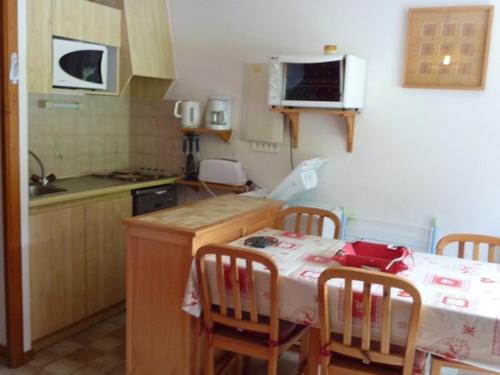 - une cuisine avec une table, des chaises, une table et un four micro-ondes dans l'établissement 3 pièces cosy au départ des randonnées, 4 pers - FR-1-573-97, à Le Biot