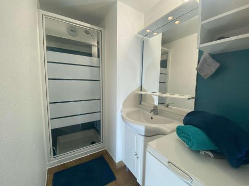 une salle de bain blanche avec un lavabo et un miroir dans l'établissement Studio mezzanine à 50m de la plage, 5 couchages, parking - FR-1-226-490, à Sainte-Maxime