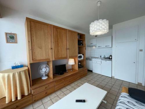 kuchnia z drewnianymi szafkami i stołem w pokoju w obiekcie Studio à St-Jean-de-Monts, avec parking, balcon et vue mer - FR-1-224C-201 w mieście Saint-Jean-de-Monts