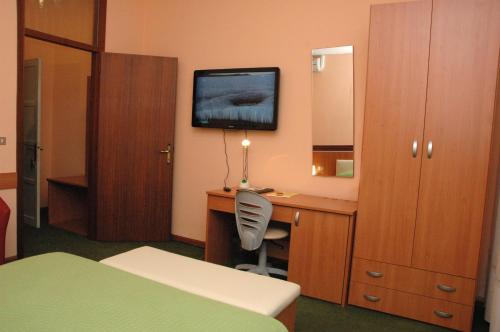 a hotel room with a desk and a tv on the wall at Hotel Da Angela in Sedegliano