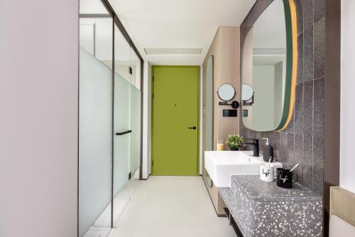 西安市にあるlyf Xi'an Dayanta by Ascott free gym & self-service free laundry roomのバスルーム(緑のドア、シンク付)