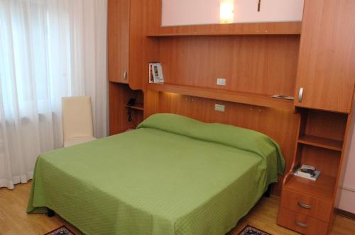 a bedroom with a green bed with wooden walls at Hotel Da Angela in Sedegliano