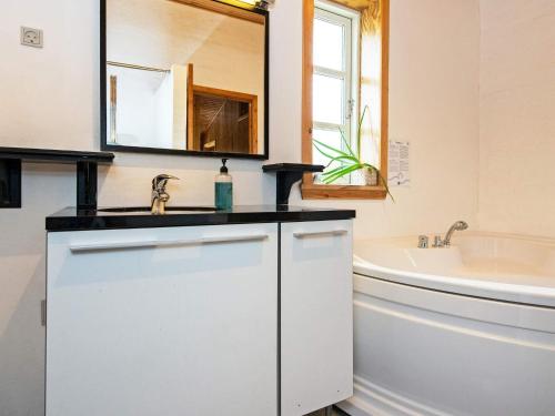 a bathroom with a sink and a tub and a mirror at 6 person holiday home in Kolind-By Traum in Kolind