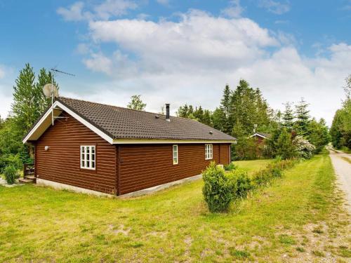 a small house in a field next to a road at 6 person holiday home in Kolind-By Traum in Kolind