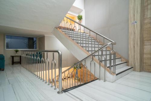 a staircase in a house with a metal railing at RedDoorz @ Glodok in Jakarta