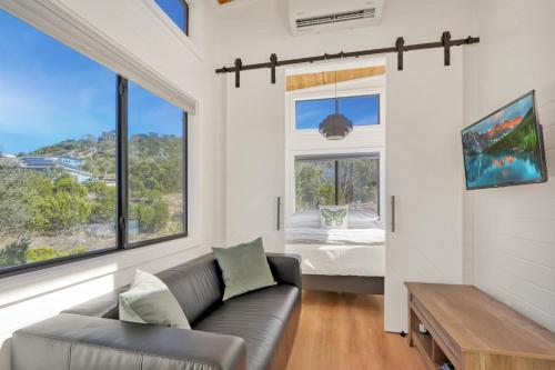 a living room with a couch and a bed and windows at Starlight Casita in Fischer