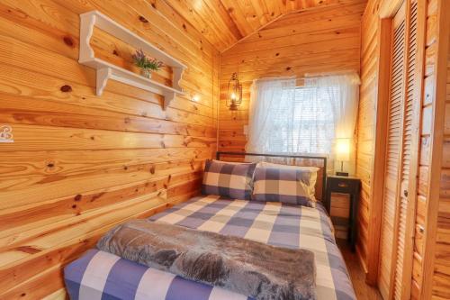a bedroom with a bed in a log cabin at Kara's Cottage in Johnson City