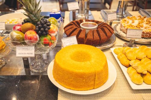 a display of different types of cakes and other desserts at Lagoon Prime Hotel in Lagoa Santa
