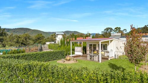 a white house with a yard with a fence at The Cottage Sojourn Kangaroo Valley in Kangaroo Valley