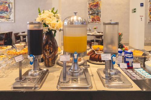 a table topped with two glasses of orange juice at Lagoon Prime Hotel in Lagoa Santa
