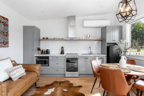 a kitchen with a couch and a table in a room at The Cottage Sojourn Kangaroo Valley in Kangaroo Valley
