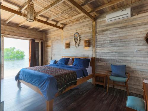 um quarto com uma cama e uma parede de madeira em Lembo Lagoon Bungalows em Nusa Lembongan