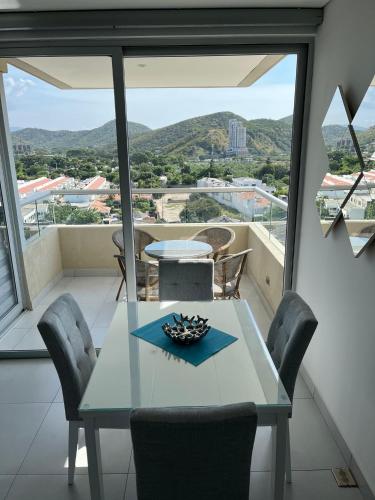 a dining table and chairs in a room with a view at Apartamento - Velas al Mar, Santa Marta in Gaira