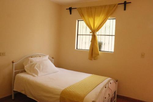 a bedroom with a white bed with a window at Casa Dolores in Dolores Hidalgo